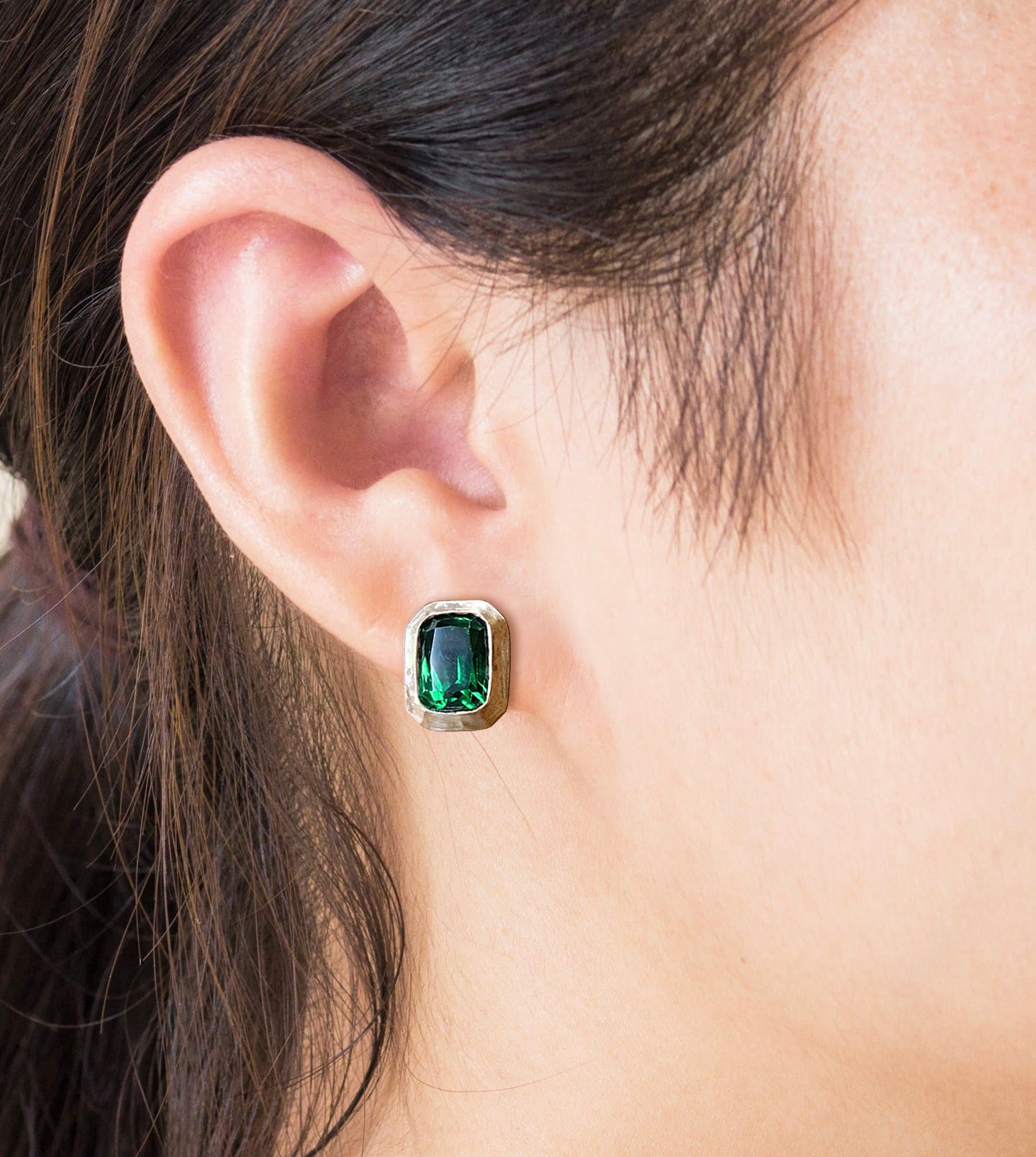 Green tourmaline stud earring in a hammered 18k gold picture-frame bezel, worn on the ear