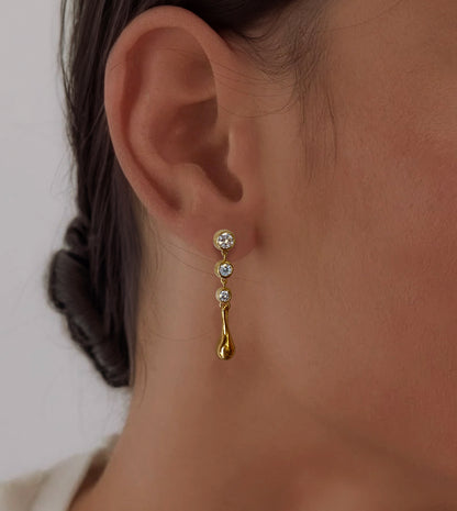 Gold diamond waterdrop earring on the ear, alternate angle showing the cascading diamonds and teardrop