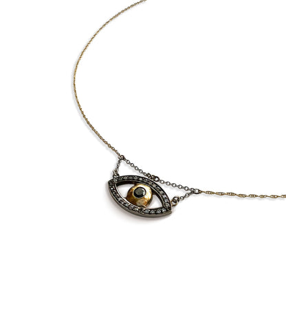 Close-up of the handcrafted evil eye pendant in 14k yellow and darkened white gold