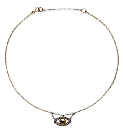 Evil eye necklace on a neutral background, gold iris with pavé white gold outline on a fine gold chain