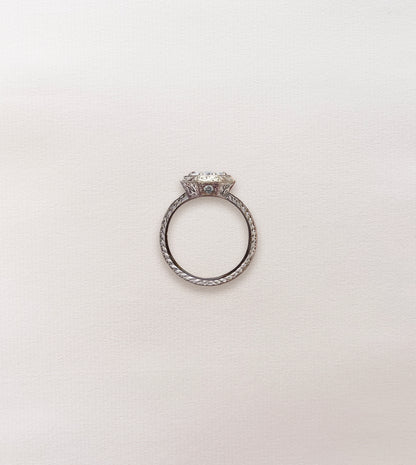Side profile of an octagonal engagement ring with a hand-engraved band and round diamond