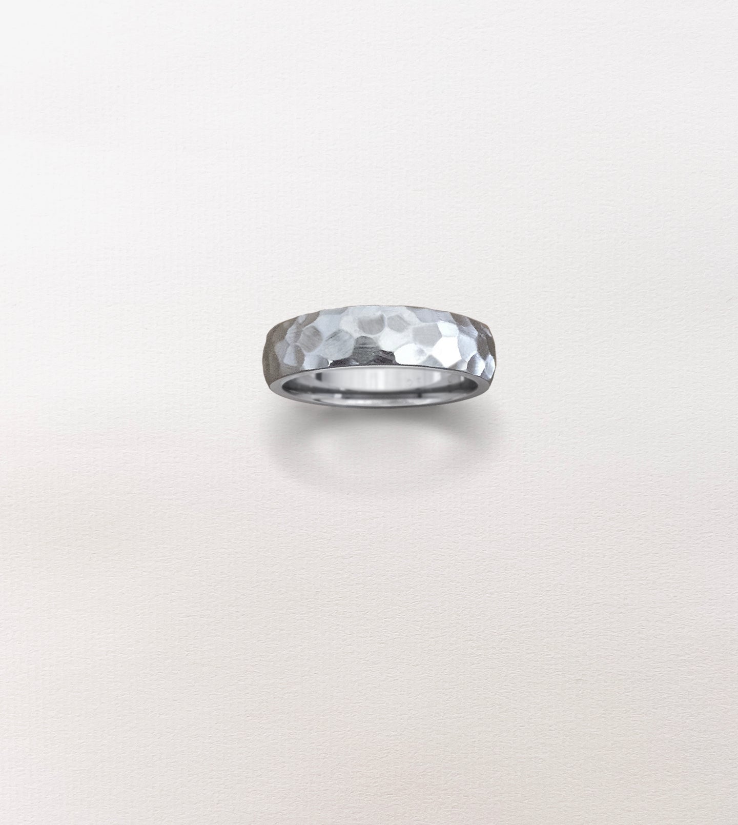 Hand-carved palladium wedding band with a faceted, divoted sculpted surface