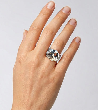Sculptural sterling silver wave ring shaped like a cresting wave