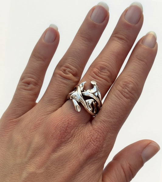 Hand-sculpted sterling silver rose thorn ring in high-shine polish, worn on woman's hand with organic curved thorns across the finger