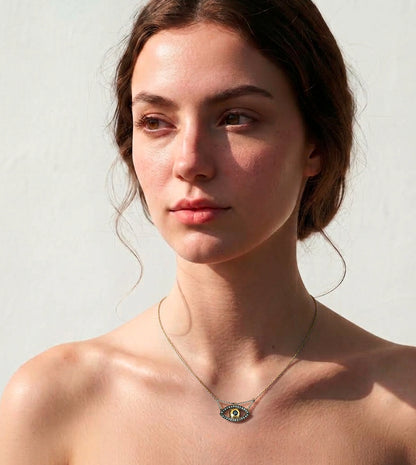 Evil eye necklace pendant pn model's neck, brushed yellow gold iris within a pavé set balckened white gold eye