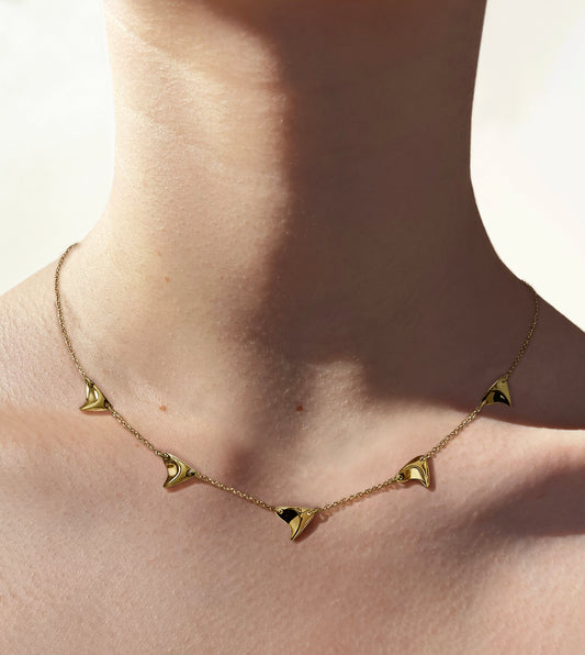 Five high shine yellow gold thorns on delicate yellow gold chain on model's neck