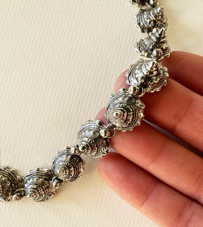 Close-up of the blackened sterling silver whelk shell spires held in hand