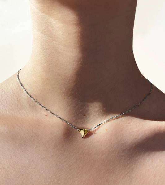 Yellow gold shiny finish rose thorn on sterling silver chain on model's neck