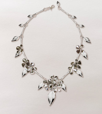 Sterling silver necklace with carved hydrangea blossoms and leaves linked along the chain