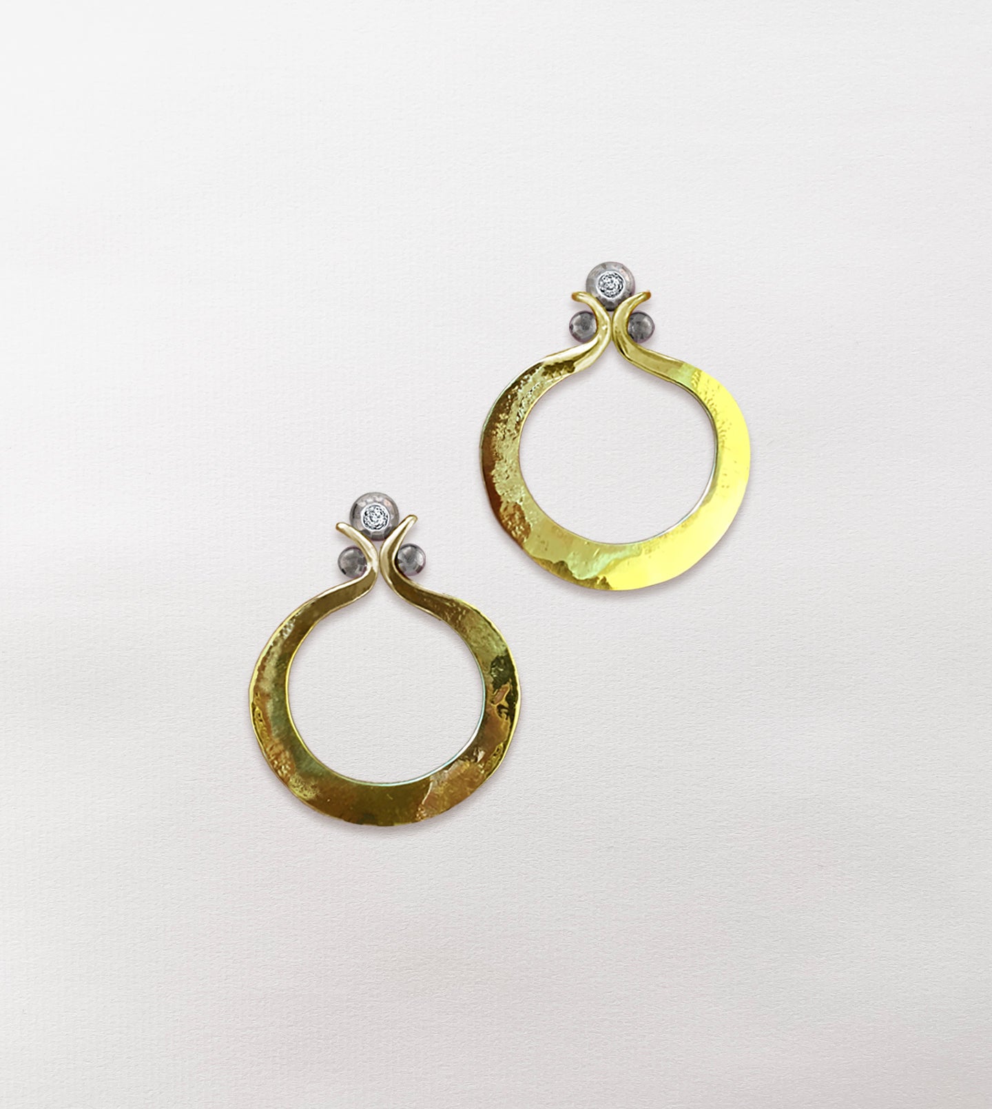 Pair of hammered yellow gold hoop earrings with diamond accents in oxidized hand-carved silver balls