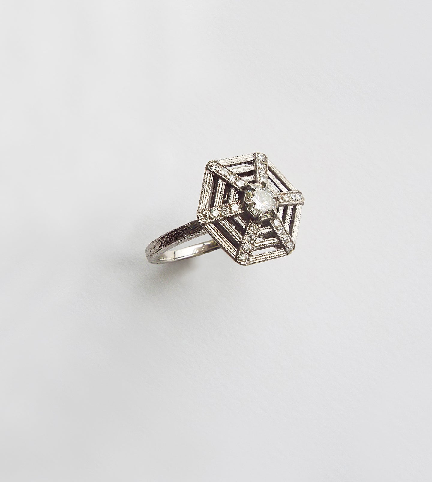 Platinum spiderweb diamond ring, angled view of the engraved hexagonal web