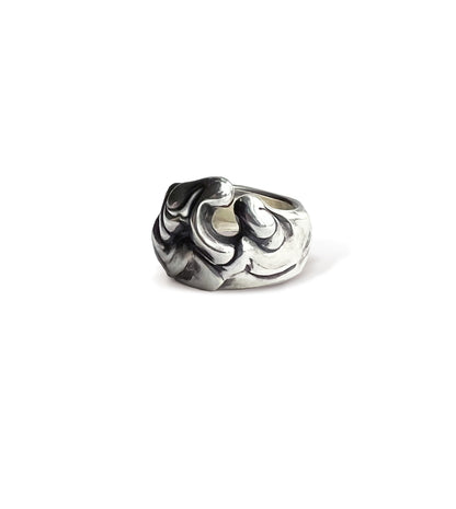 Polished, blackened sterling silver wave ring on a light grey background