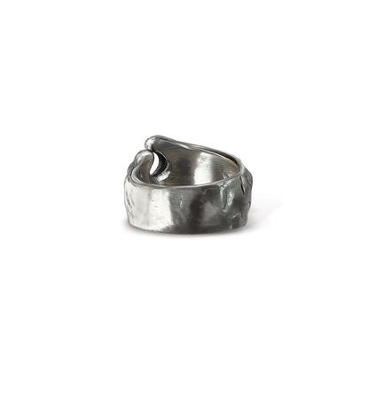 Brushed, blackened sterling silver wave ring on a light grey background