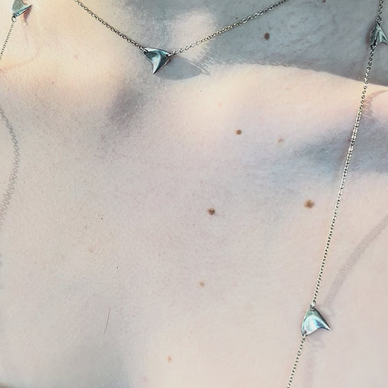 Video of sterling silver rose thorn necklace in a brushed  finish on a woman's neck in closeup