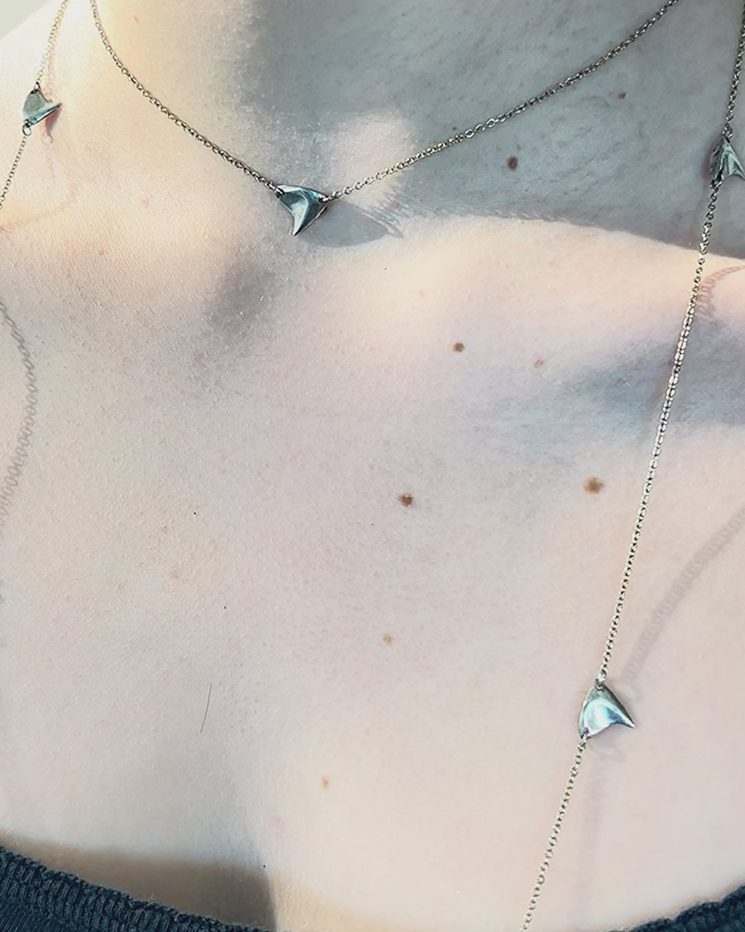 Video of sterling silver rose thorn necklace in a brushed  finish on a woman's neck in closeup